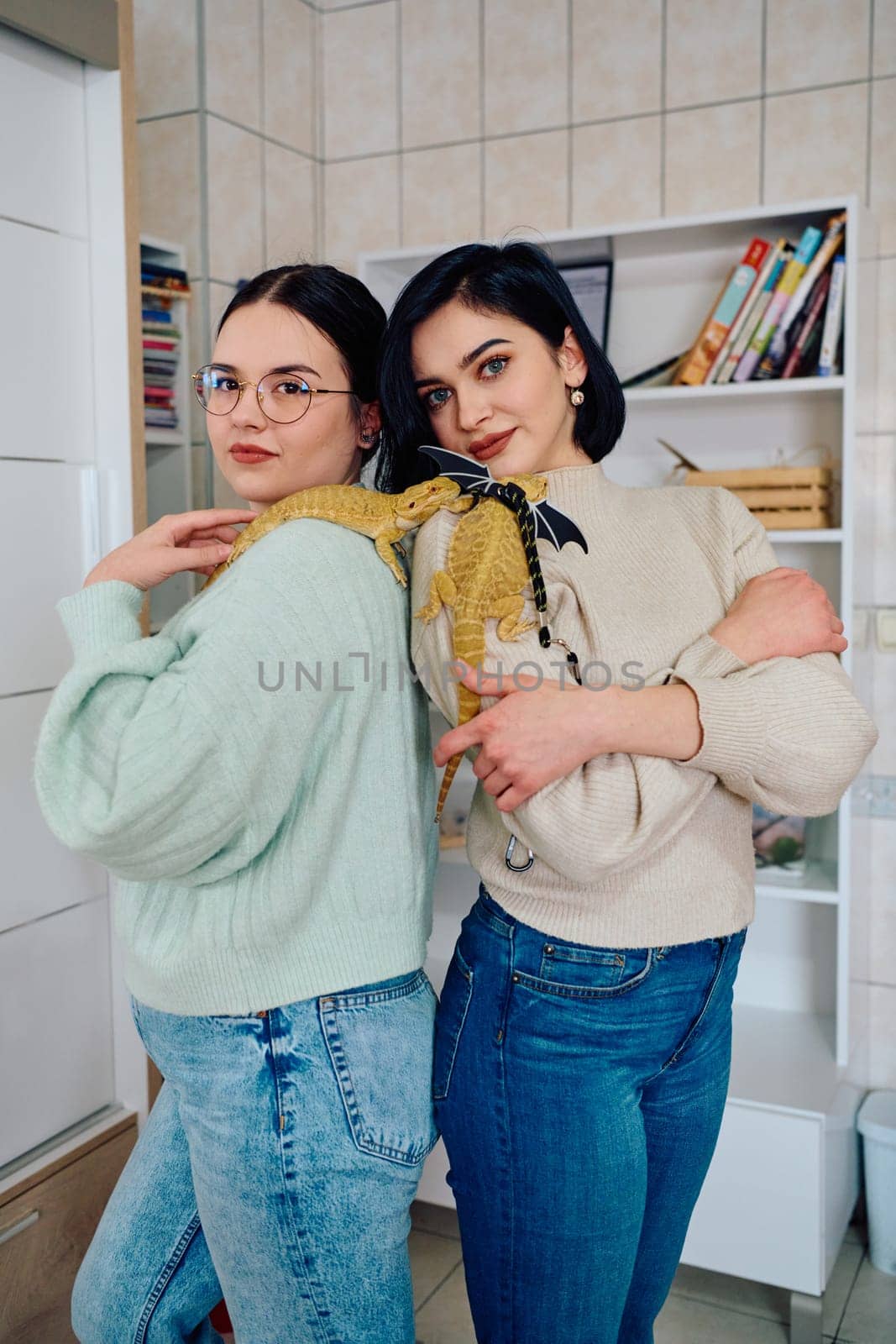 The sisters' smiles and the lizard's calm demeanor suggest that they are all enjoying each other's company.