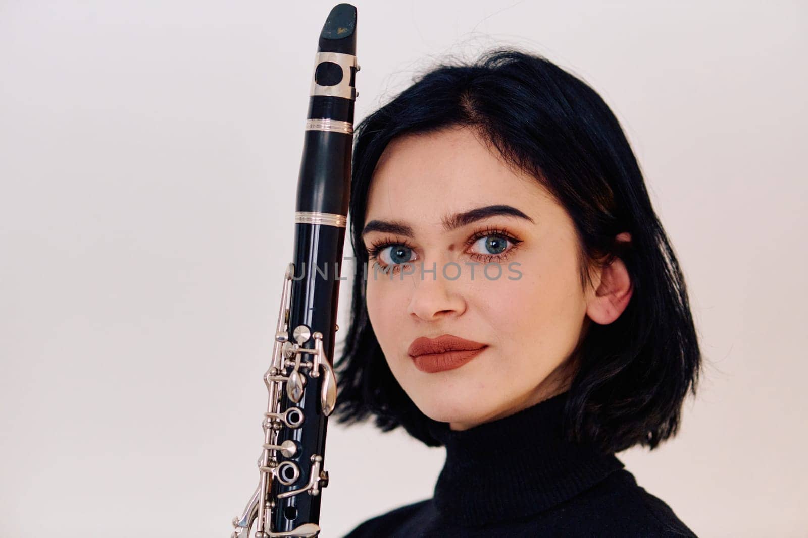 Graceful Brunette Musician Posing with Clarinet on White Background by dotshock