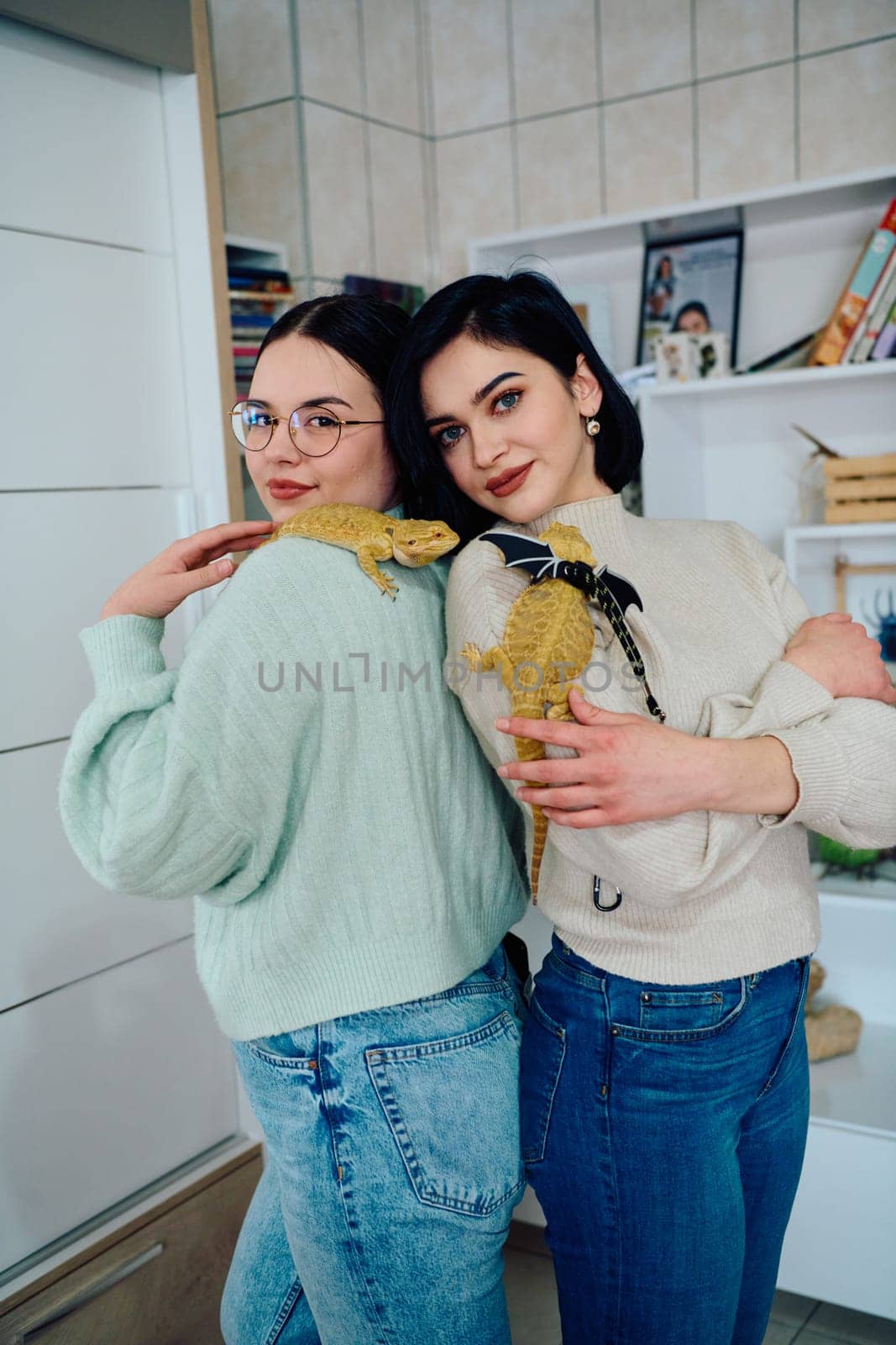 The sisters' smiles and the lizard's calm demeanor suggest that they are all enjoying each other's company.