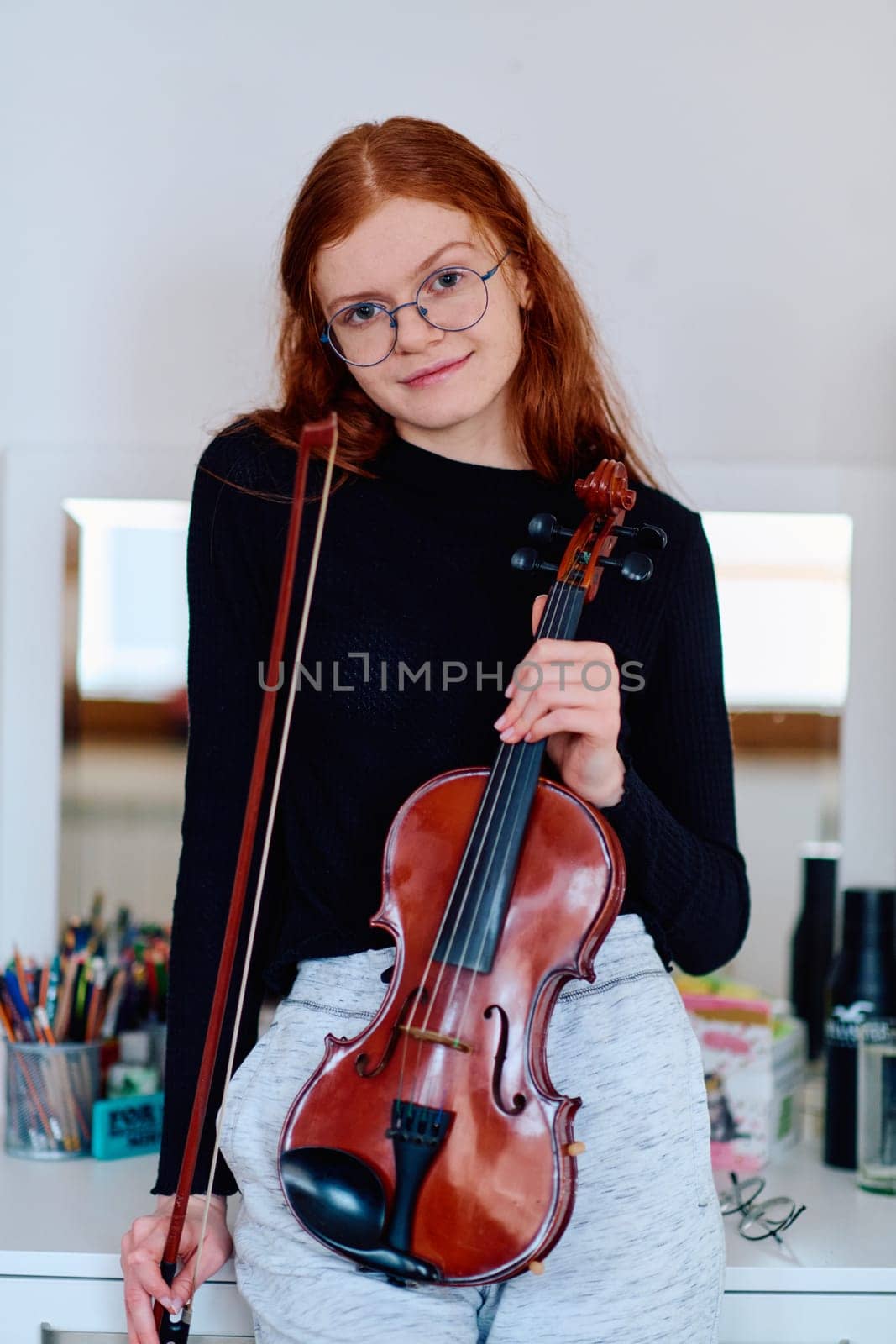 A stunning redhead musician exudes elegance as she poses with her violin, embodying both grace and musical prowess.