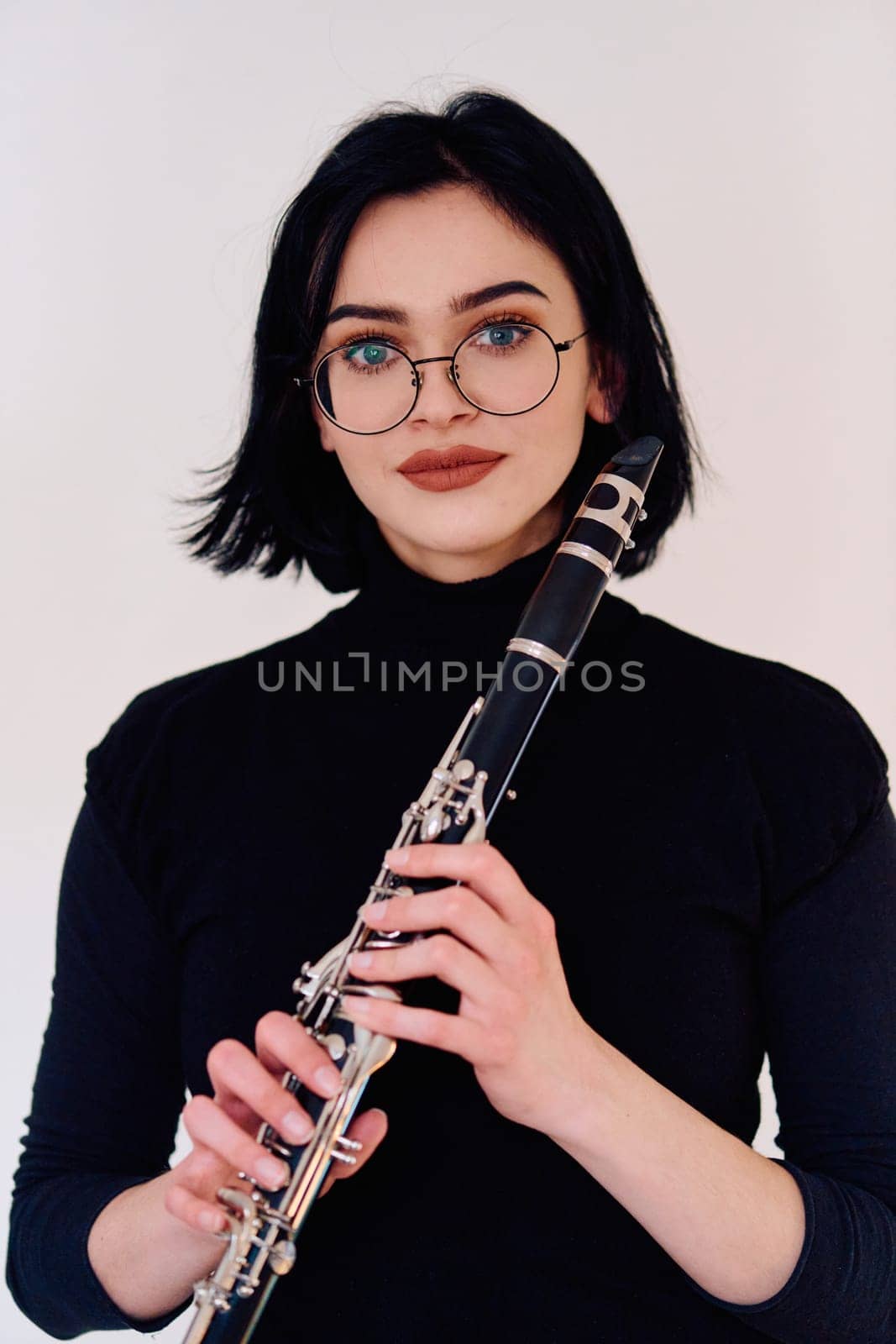 Graceful Brunette Musician Posing with Clarinet on White Background by dotshock