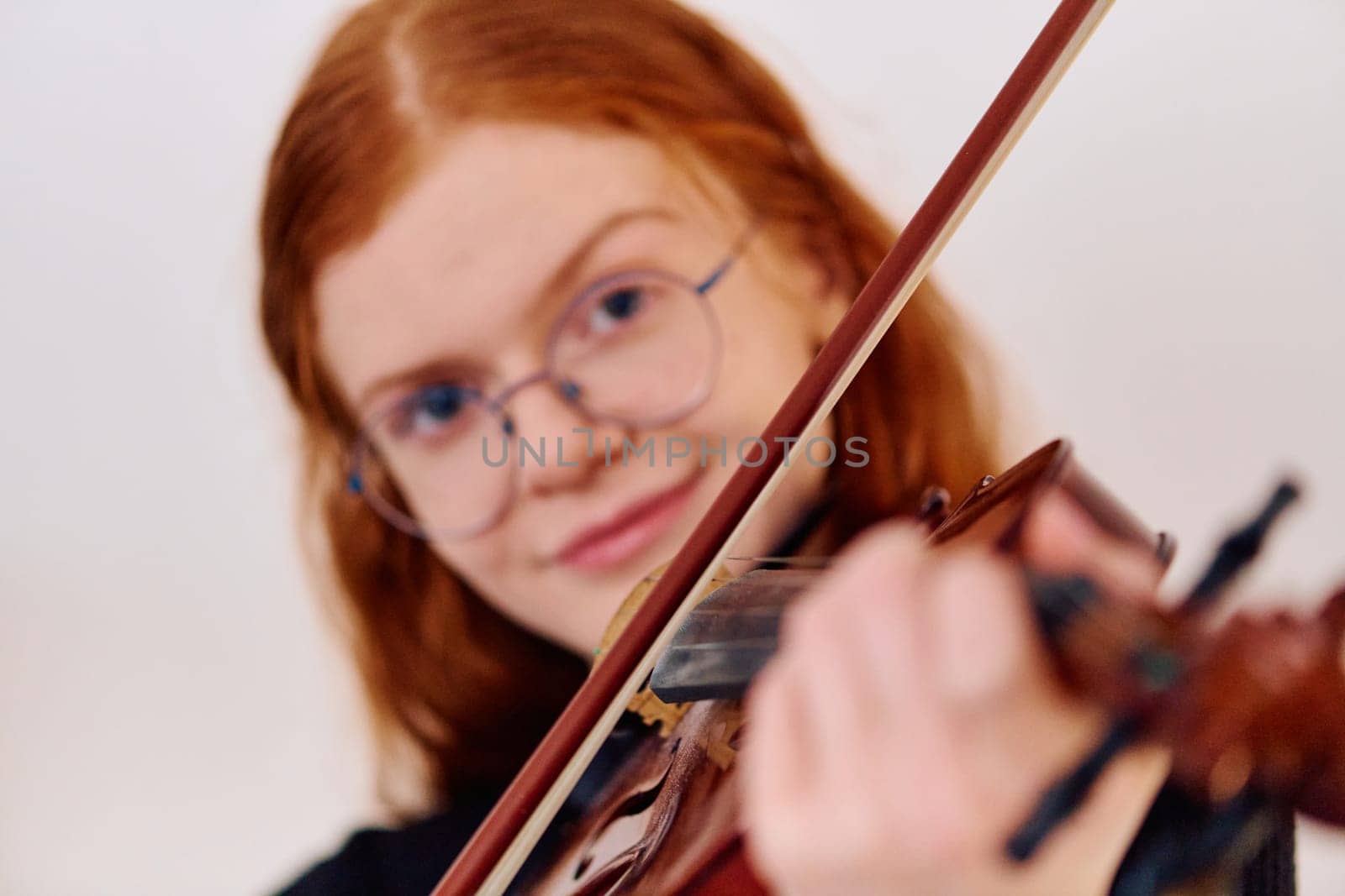 A stunning redhead musician exudes elegance as she poses with her violin, embodying both grace and musical prowess.