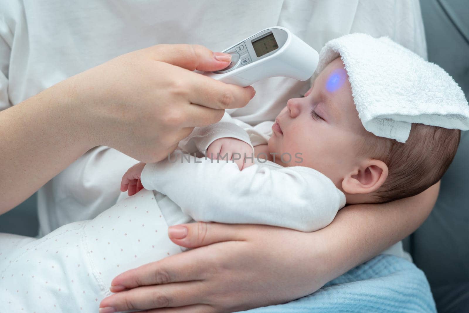 A devoted mother trusts an electronic thermometer, ensuring her newborn's health by measuring the