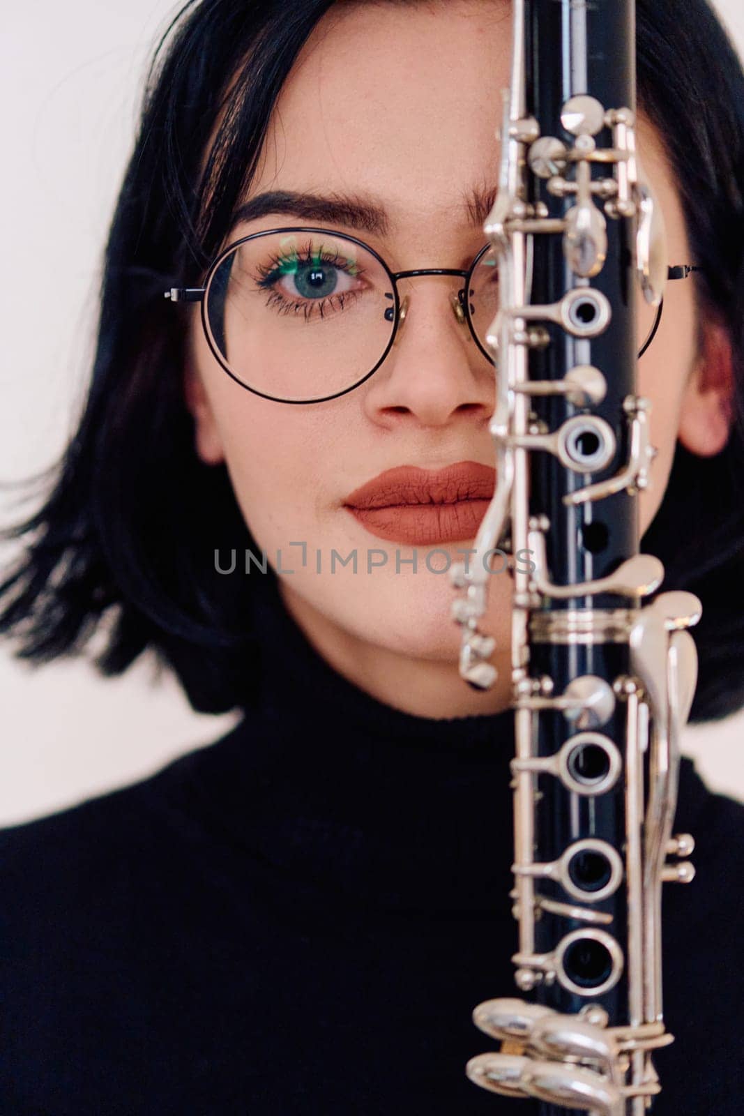 Graceful Brunette Musician Posing with Clarinet on White Background by dotshock