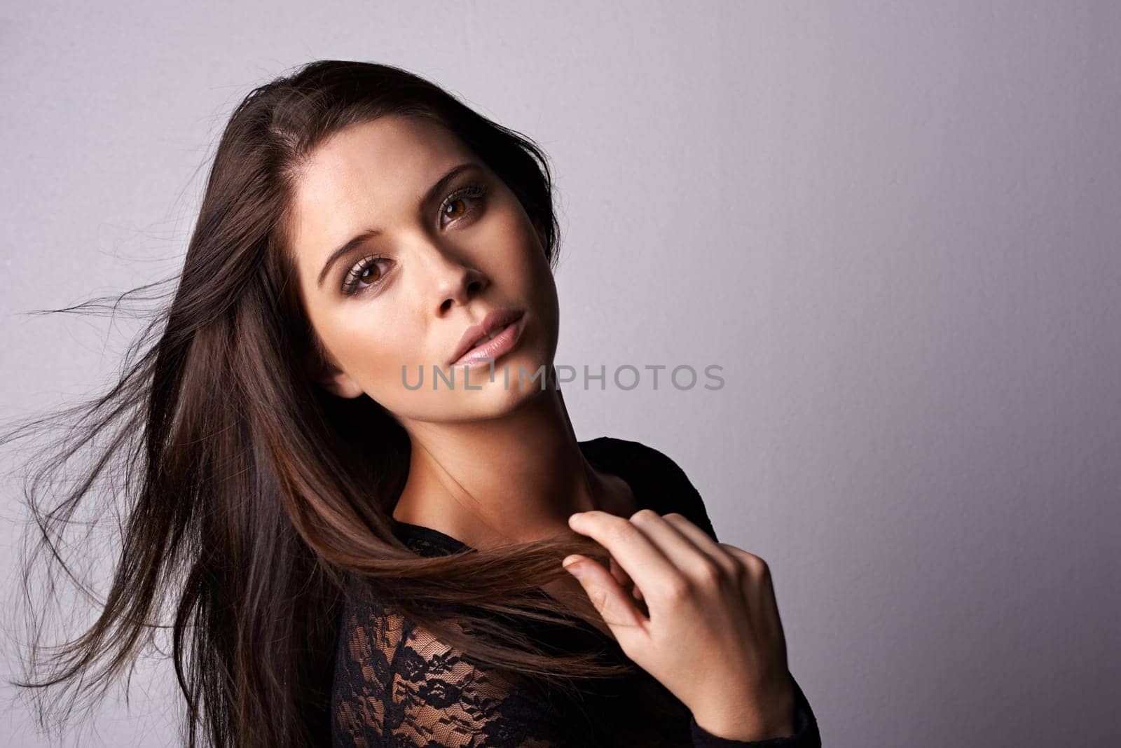 Makeup, hair and portrait of woman in studio for beauty, cosmetics or wellness on grey background. Glamour, makeover and female model with haircare results, shampoo or growth, texture or satisfaction.