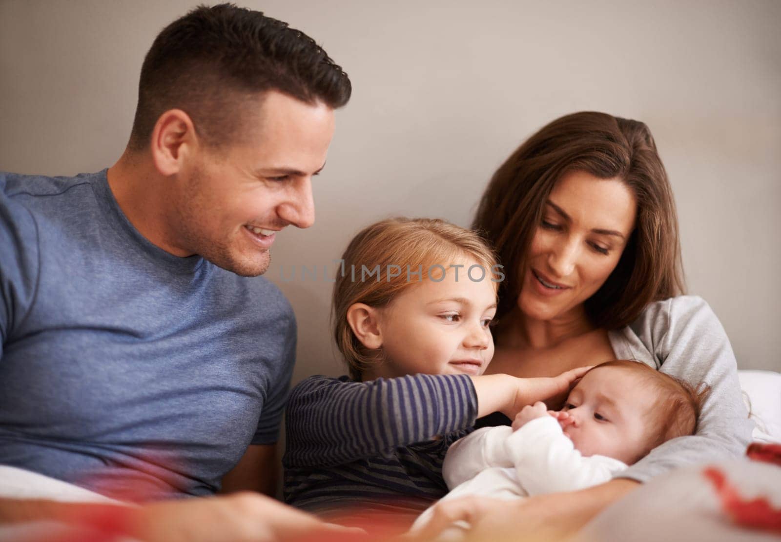 Home, family and parents with baby, kids and bonding together with happiness and care in the morning. Bedroom, mother and father with children and holding infant with comfort, smile and weekend break.