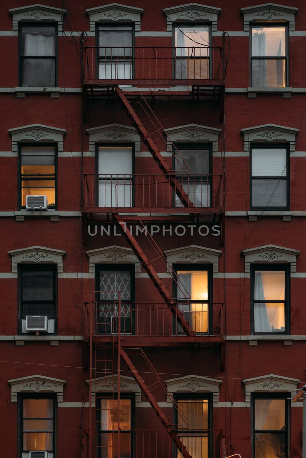 Charming New York Architecture with Fire Escapes and Lit Windows by apavlin