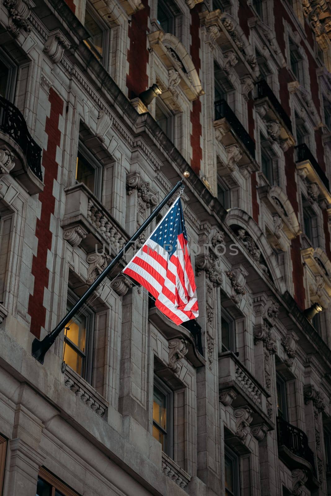 Proud American Flag Hanging from Traditional New York Architecture by apavlin