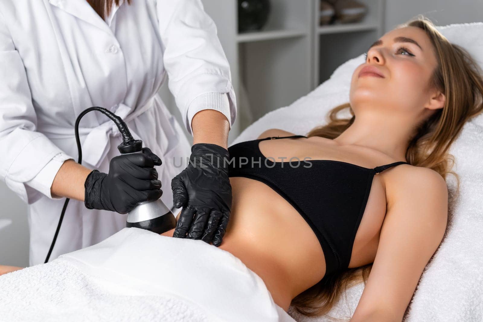 Young woman undergoes ultrasound cavitation procedure for skin tightening by vladimka