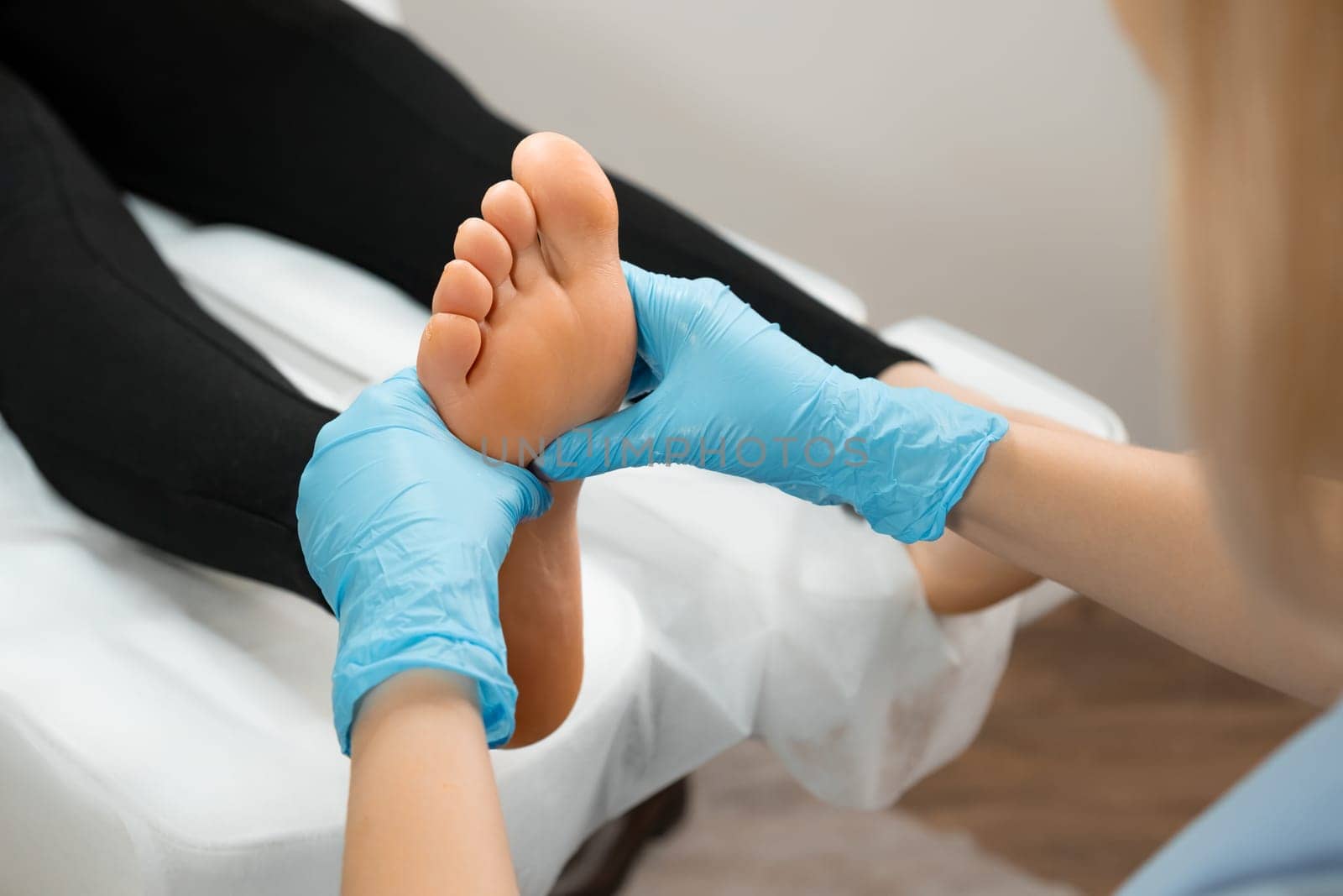 Young woman having professional feet massage in beauty salon. by vladimka