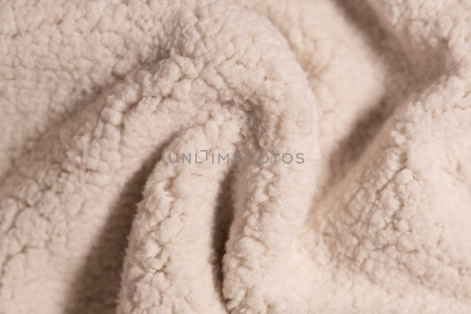 Top view of white soft sheepskin textile plaid. Warm cozy texture background.