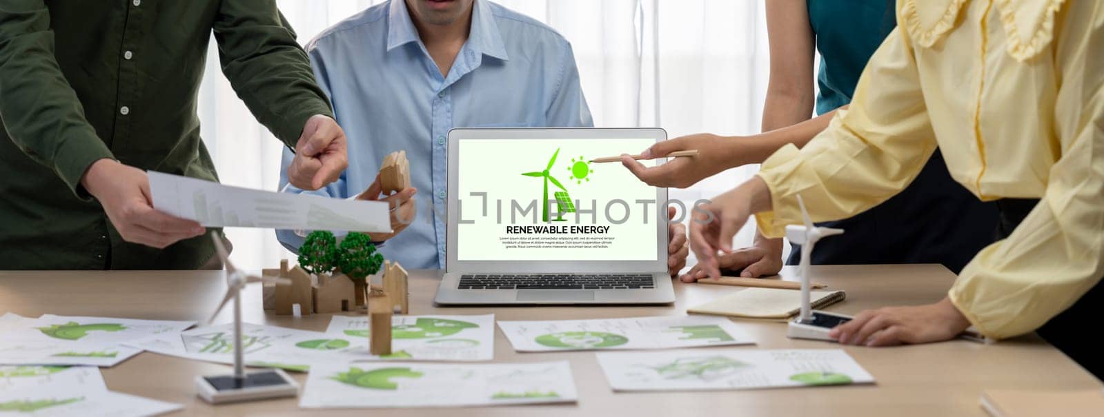 Renewable energy logo displayed on green business laptop while business team represented green design to customer. ESG environment social governance and Eco conservative concept. Closeup. Delineation.