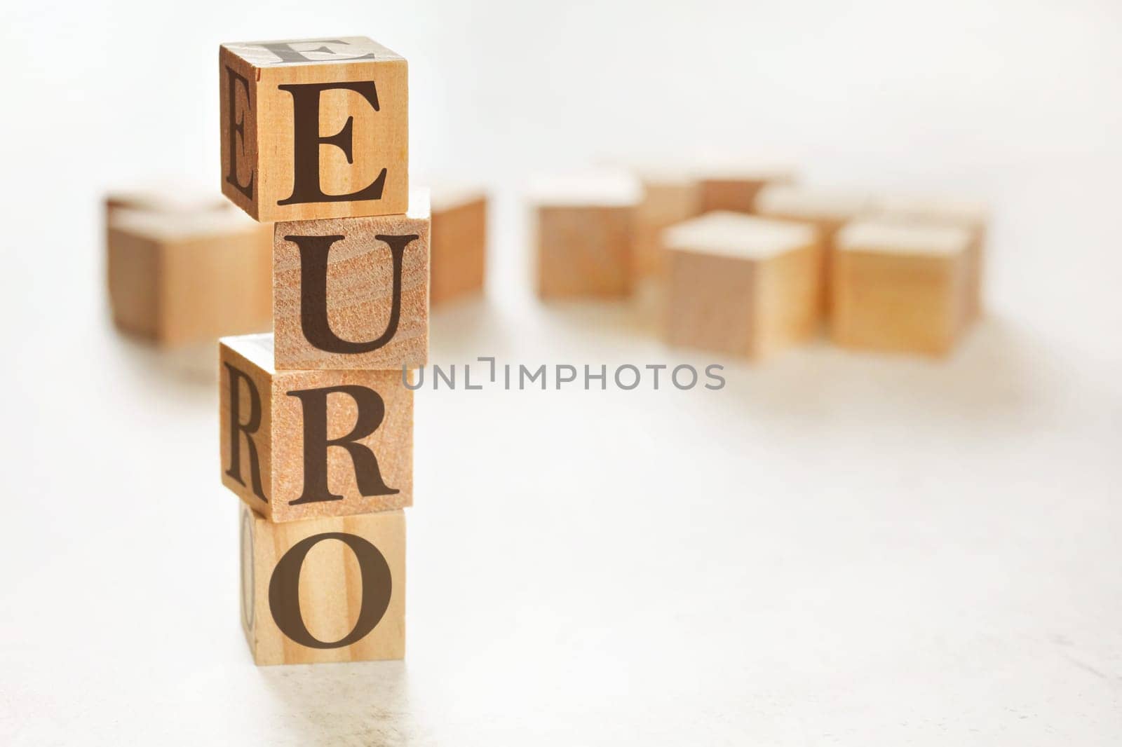 Four wooden cubes arranged in stack with word EURO on them, space for text / image at down right corner by Ivanko