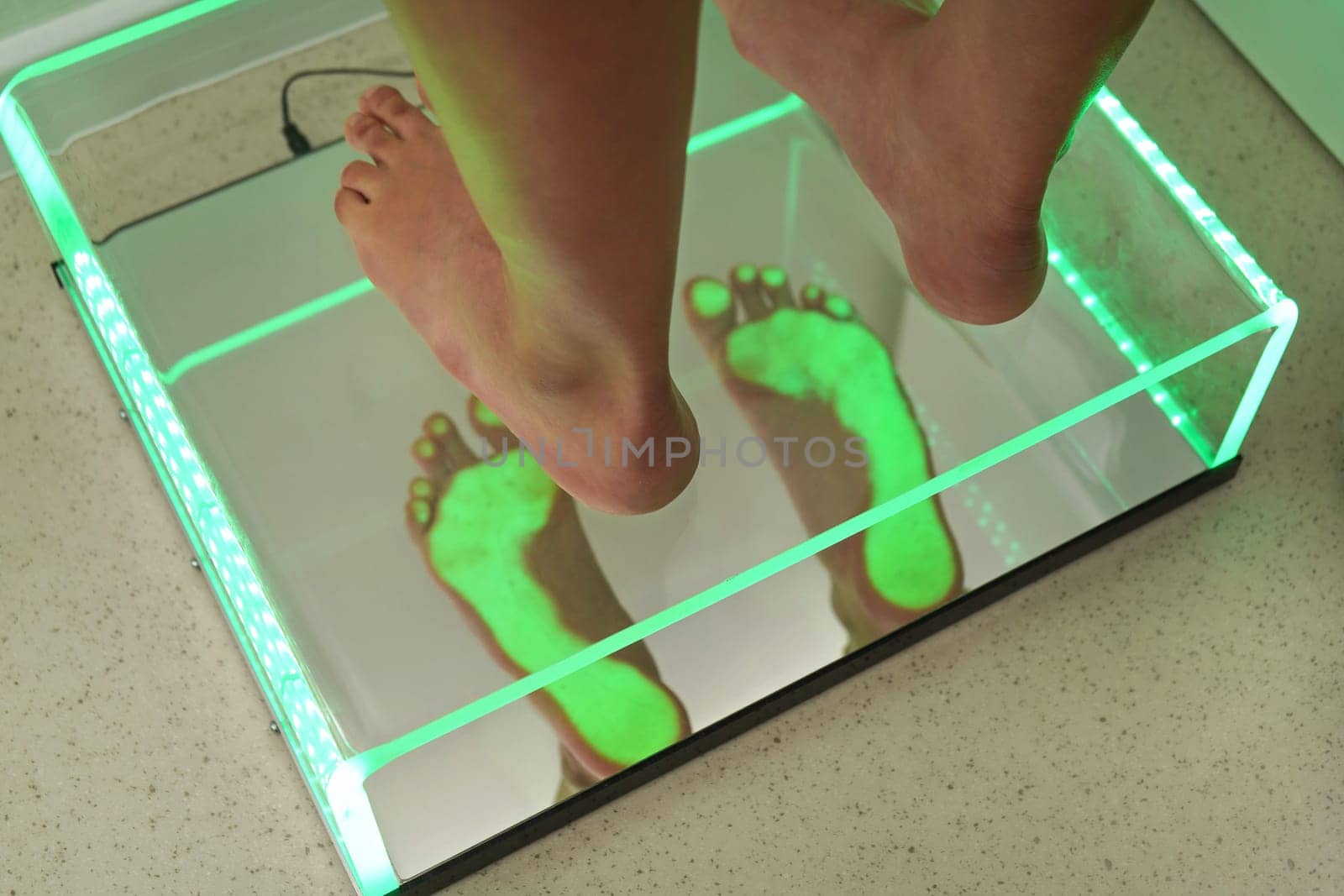 Foot step analysis on feet scanner - footprints visible in green light on plastic panel by Ivanko