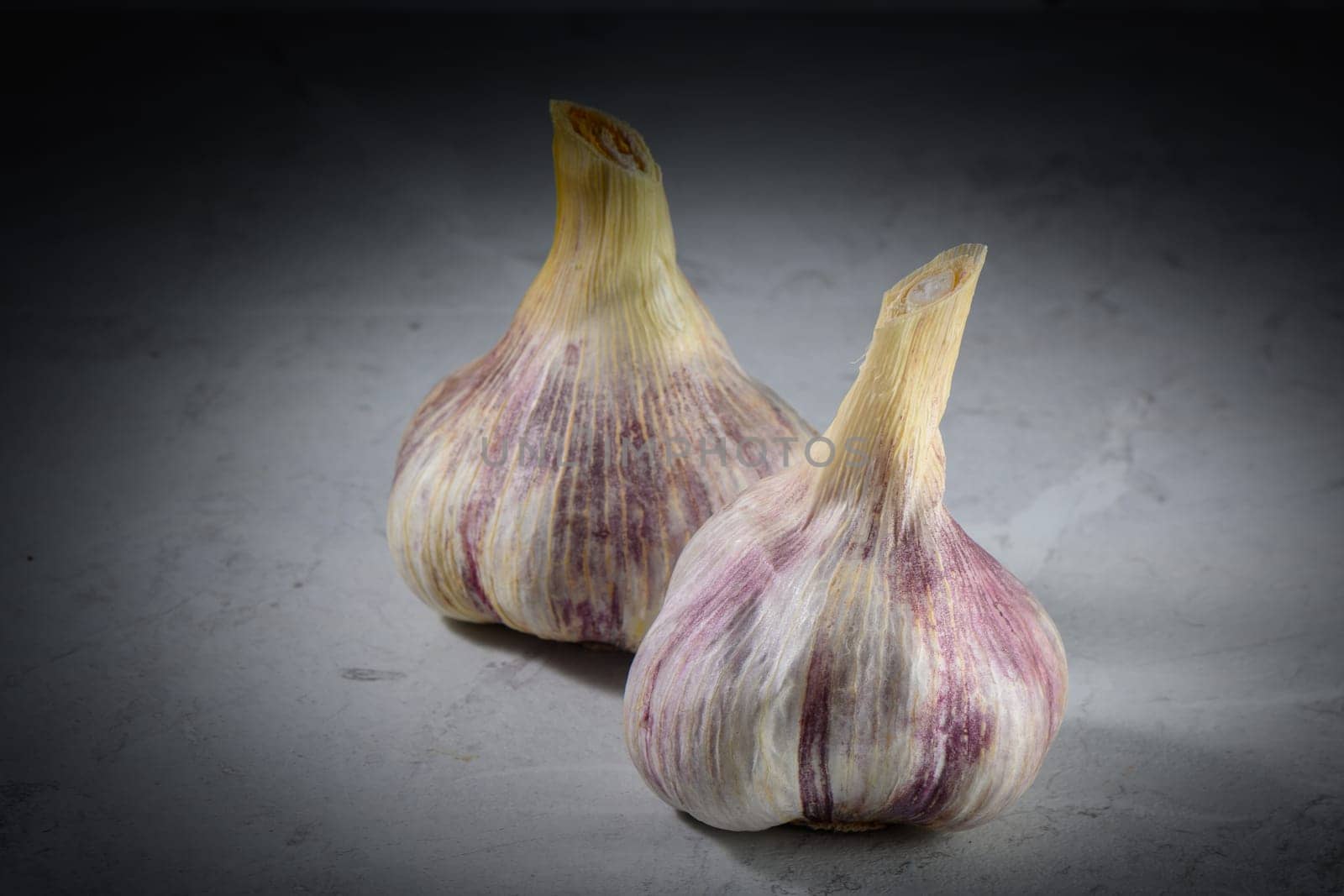 Still life photo of organic whole garlic on a light stone background 2