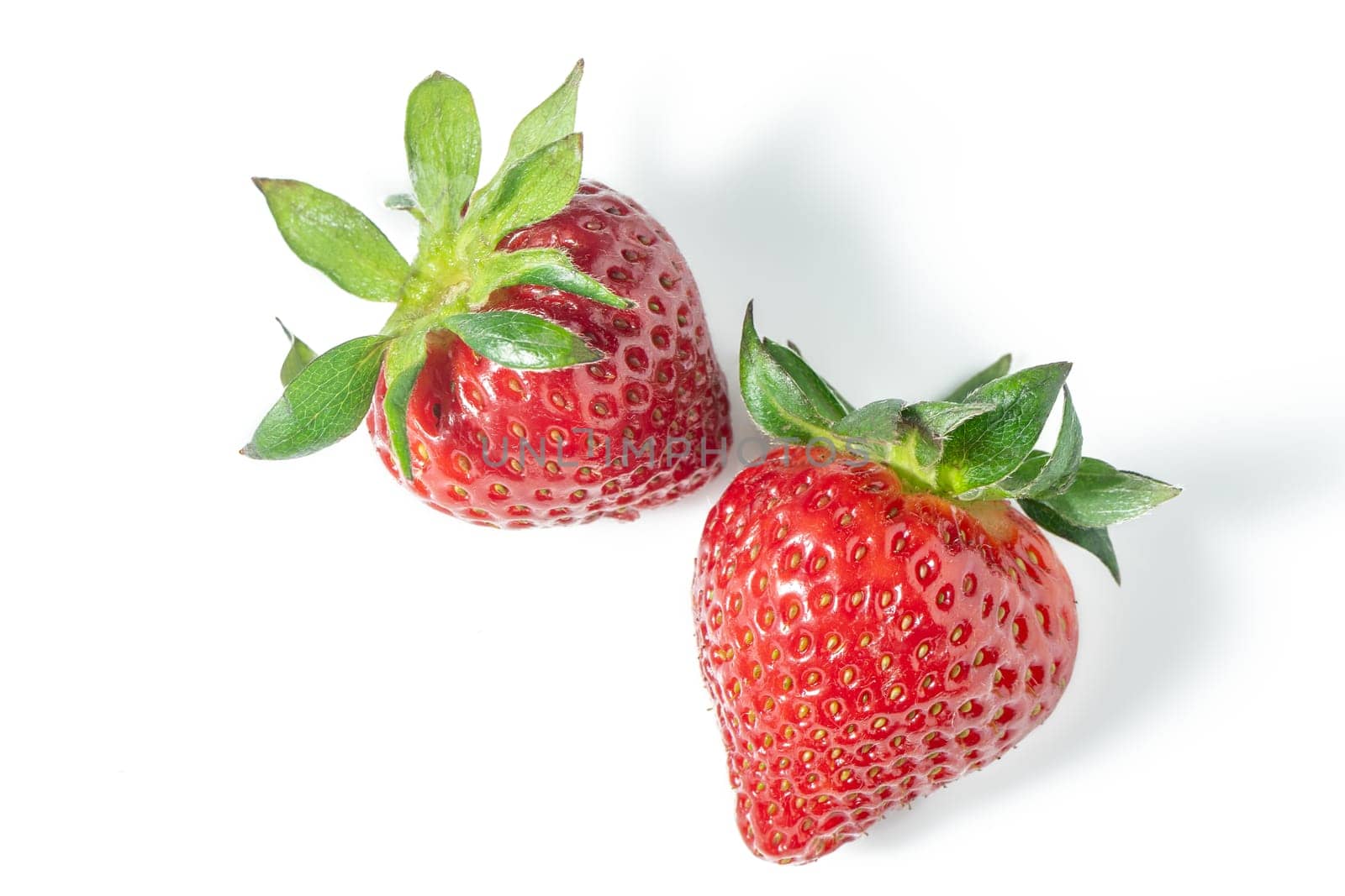 Two strawberries close up on white background 2
