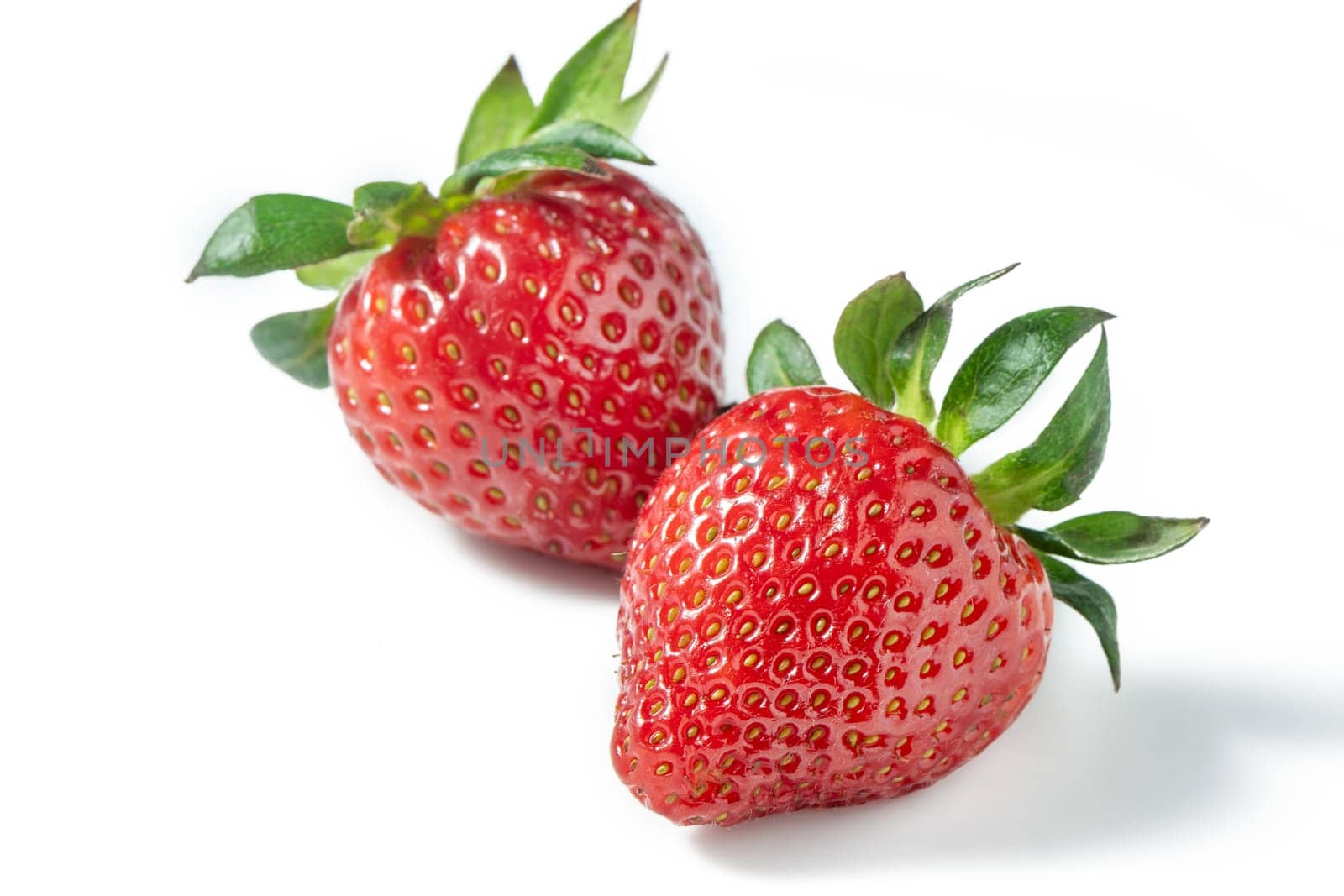 Two strawberries close up on white background 1