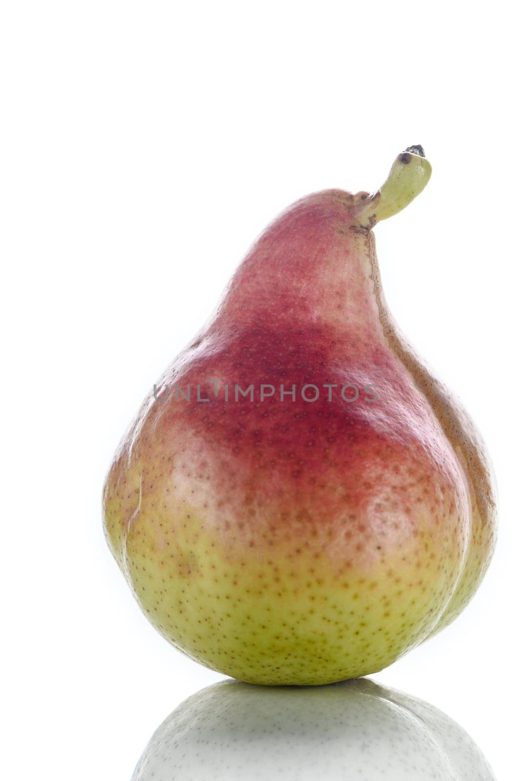 An upright ripe juicy golden and red pear isolated against a flat background. 2 by Mixa74