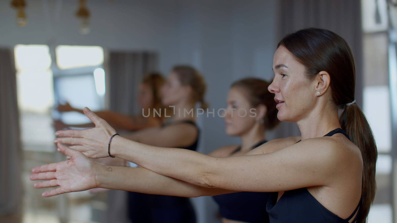 Side view of young ladies starting workout at the gym. Media. Concept of body care and fitness