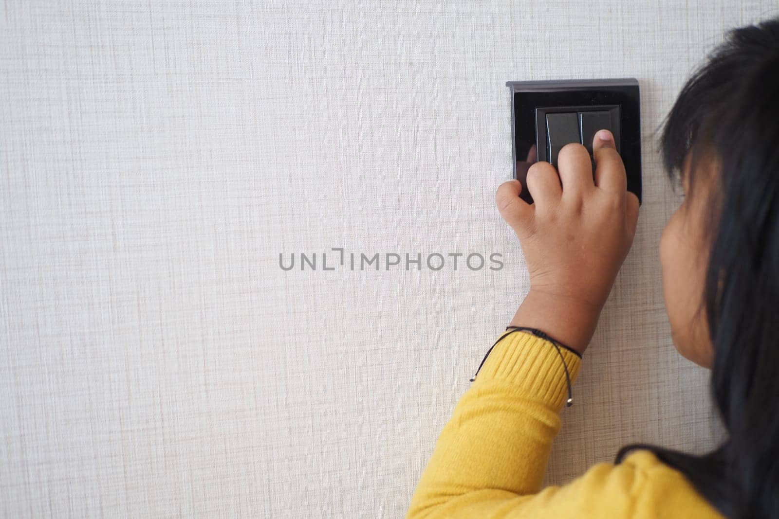 child finger turning on lighting switch with copyspace by towfiq007