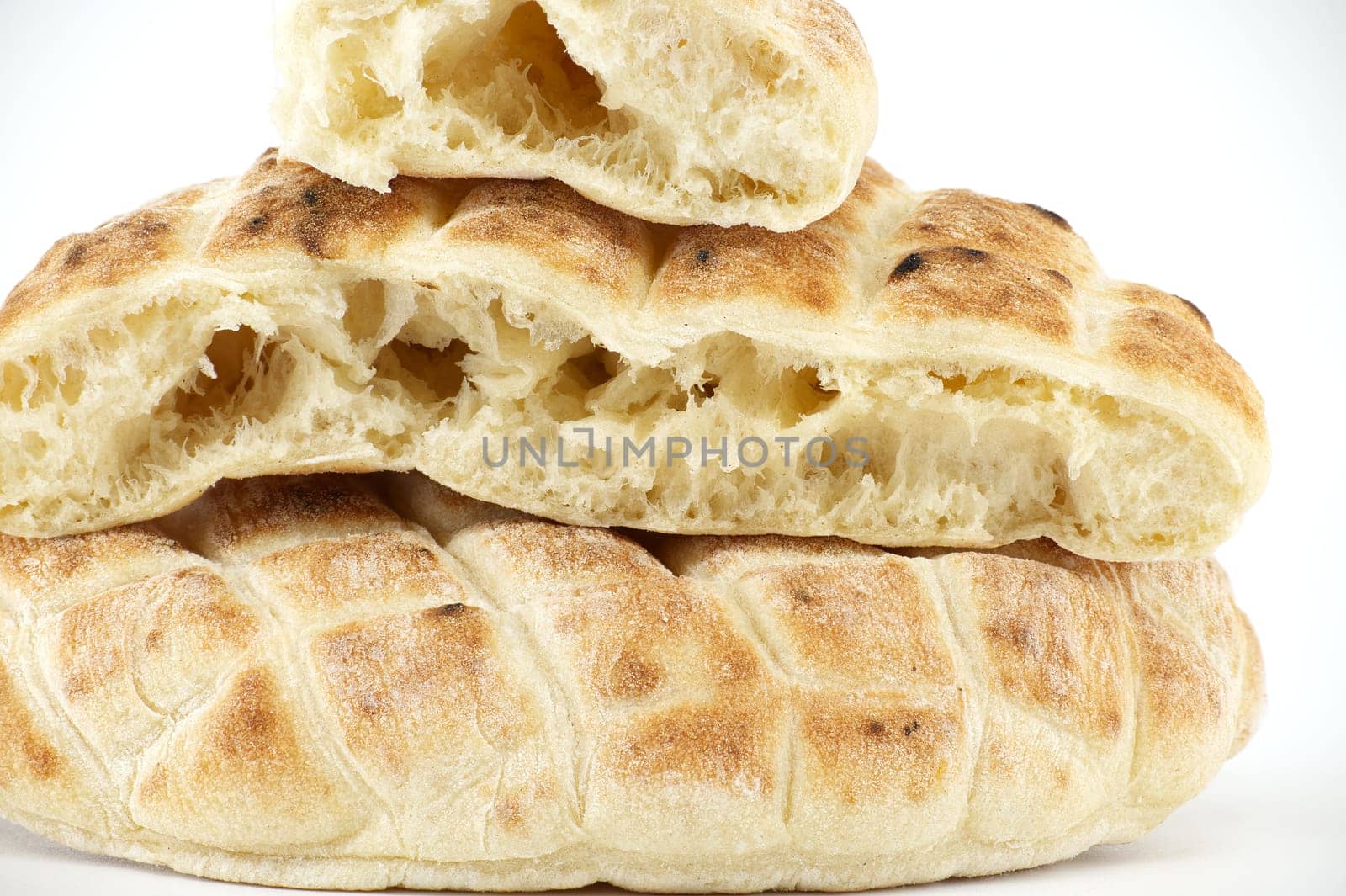 Pieces of pita flat-bread are stacked atop each other isolated on white background, typical fast food item, with the potential to be used as a snack