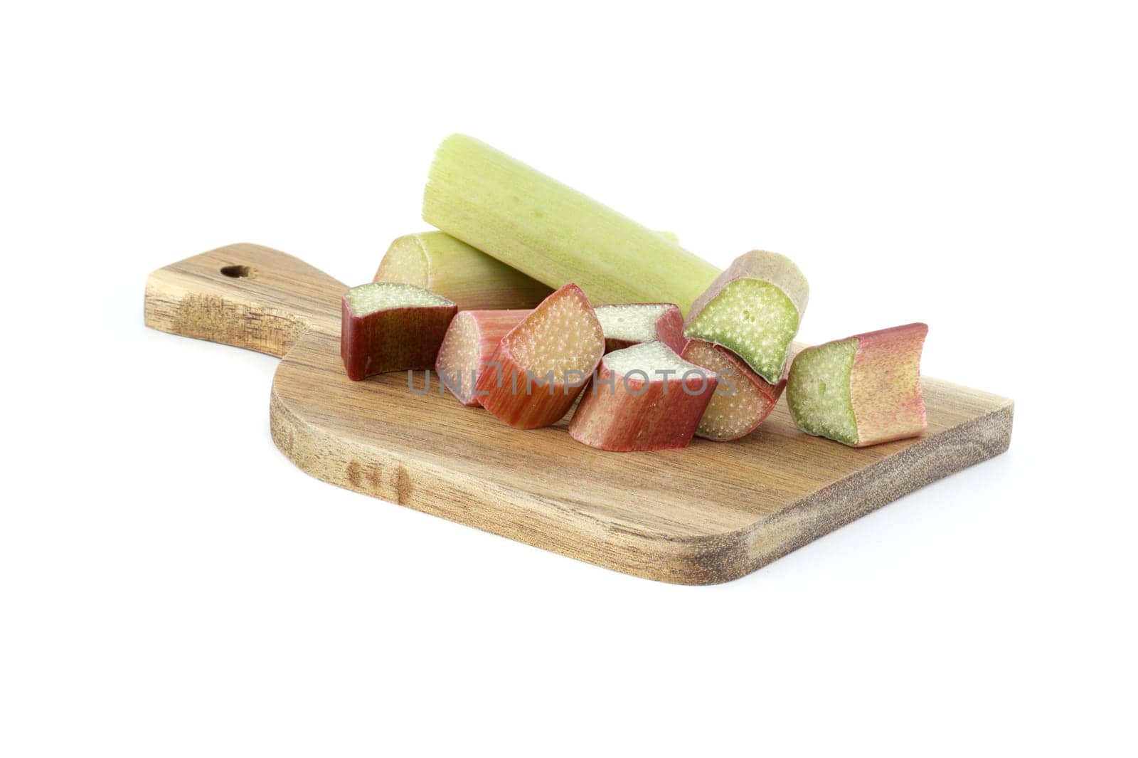 Variety of rhubarb stalks of varying colors from pale green to deep red on wooden cutting board isolated on white background
