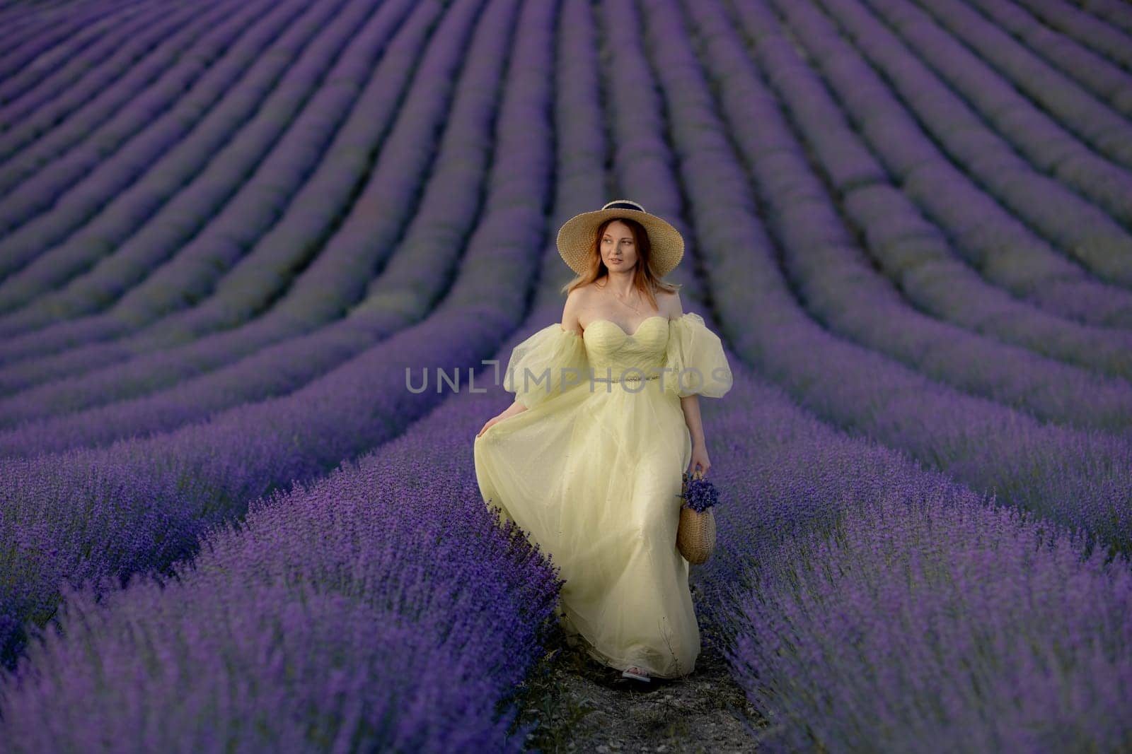 Woman poses in lavender field. Happy woman in yellow dress holds lavender bouquet. Aromatherapy concept, lavender oil, photo session in lavender by Matiunina