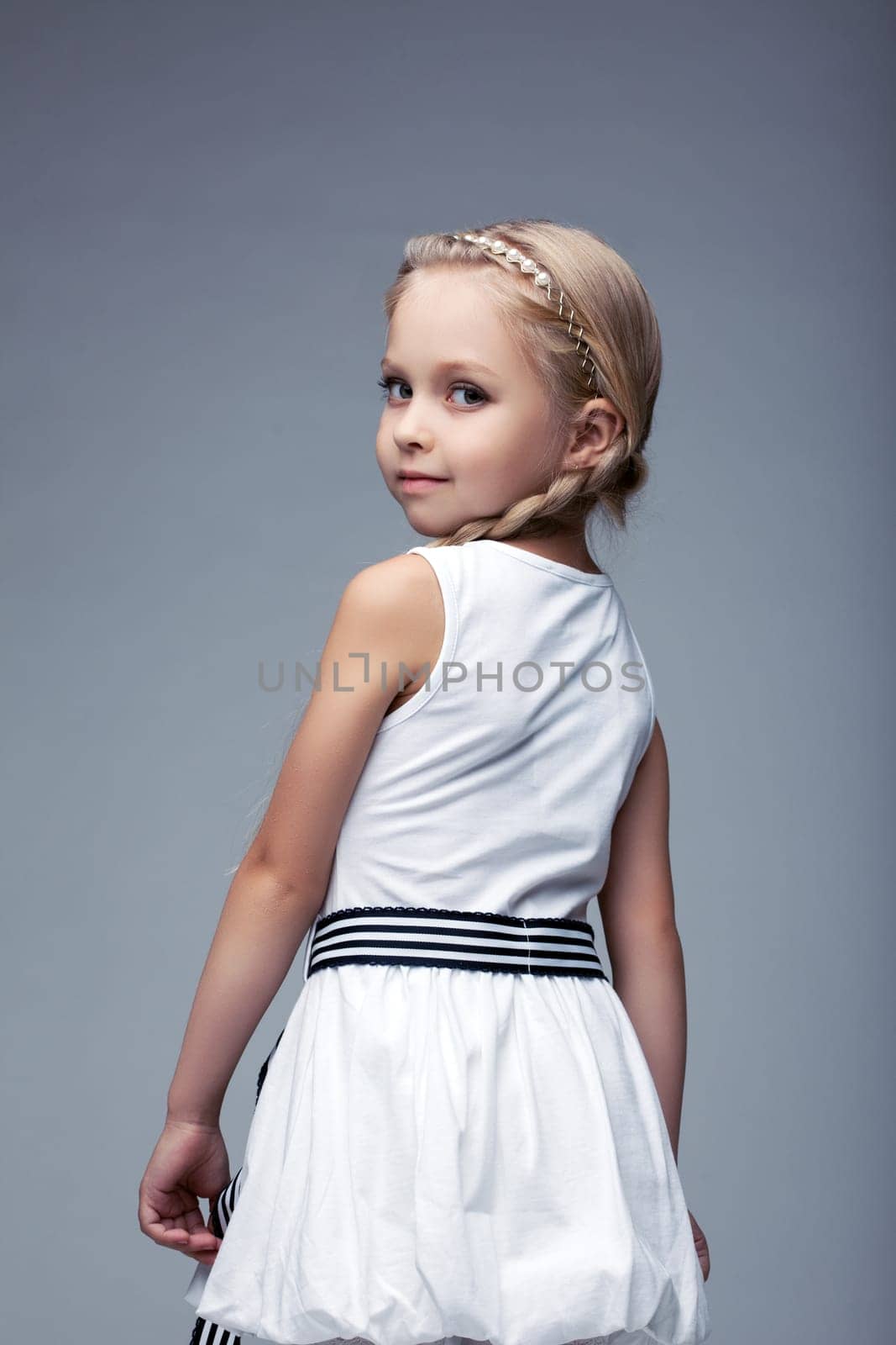 Studio portrait of little girl in white dress