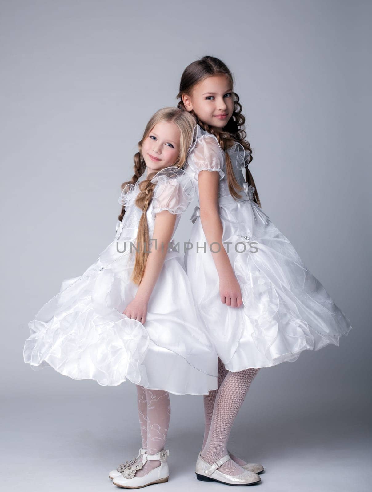 Full length portrait of little girls in white dresses