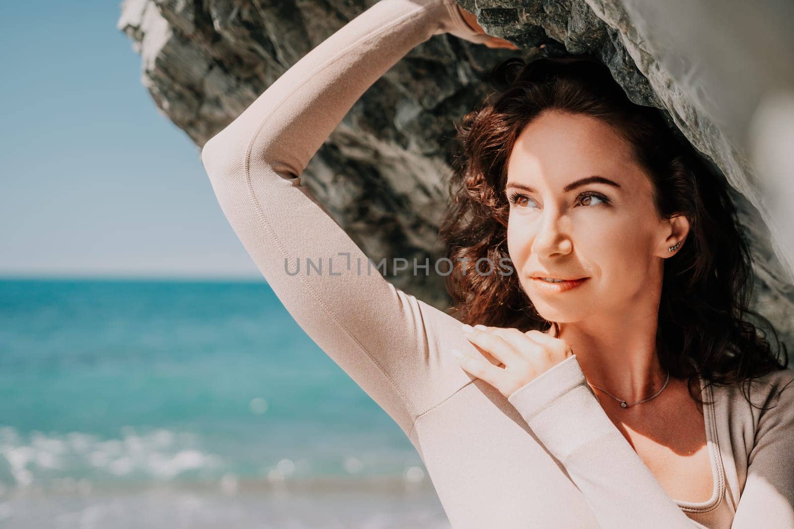 Happy young attractive brunette woman in red swimsuit, on the beach and sea background. Holiday vacation and travel concept.