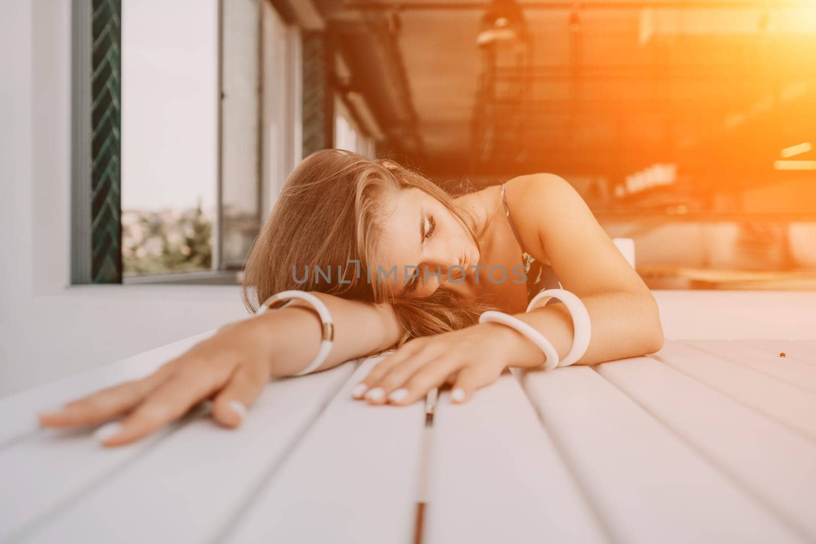 Happy woman portrait in cafe. Boho chic fashion style. Outdoor photo of young happy woman with long hair, sunny weather outdoors sitting in modern cafe. by panophotograph