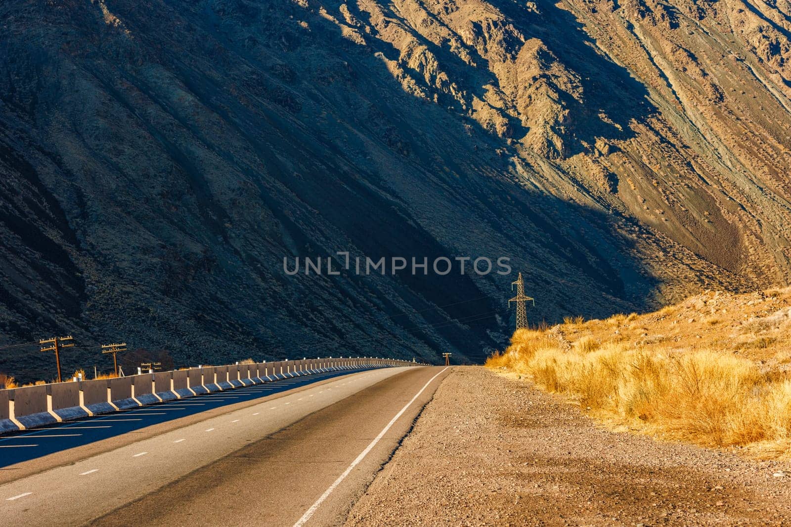 Desolate asphalt thoroughfare cuts through mountainous natural landscape by z1b