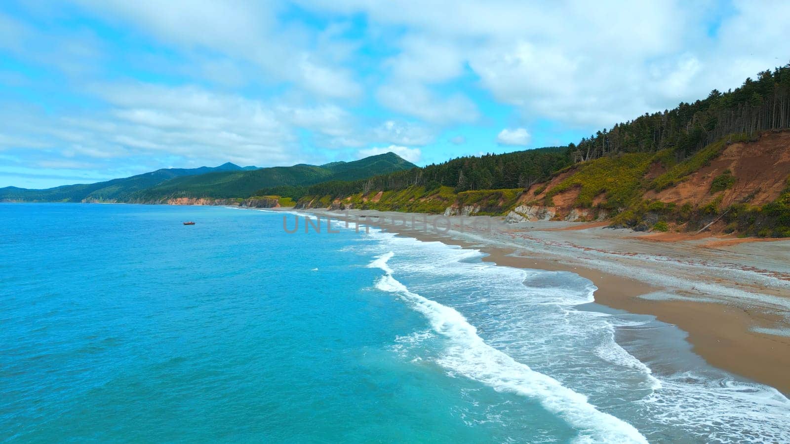 Top view of beautiful coast with turquoise water. Clip. Amazing coastline landscape with turquoise water and green forest. Paradise place on coast of sea with forest mountains by Mediawhalestock