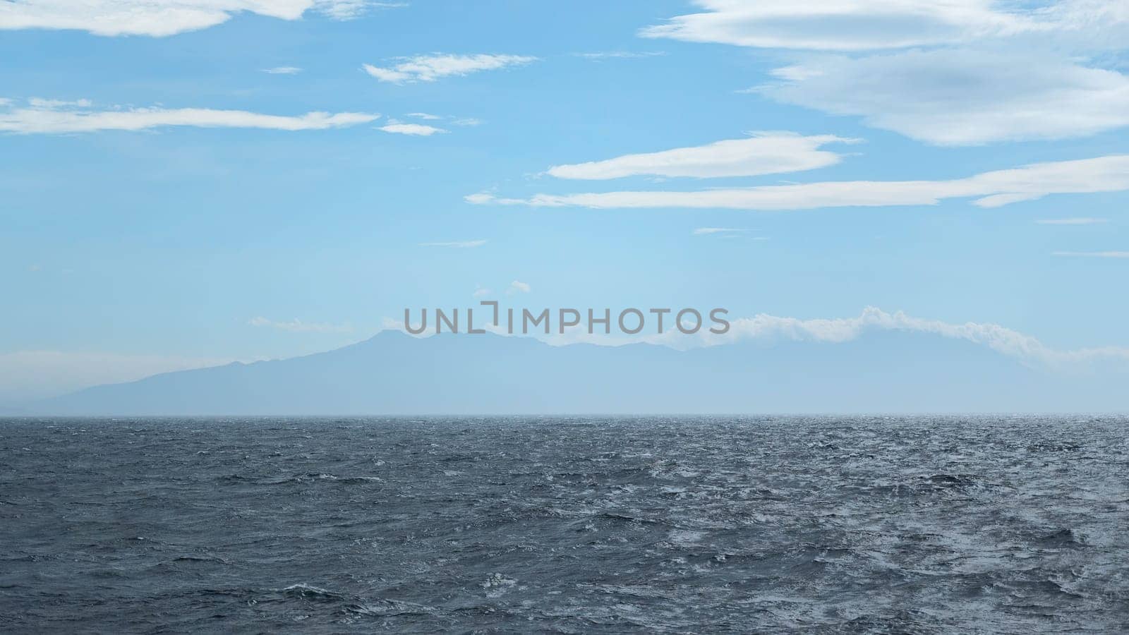Beautiful seascape from water to mountain on horizon. Clip. View from floating boat to sea horizon and mountain coast. Sea trip by boat in sea.