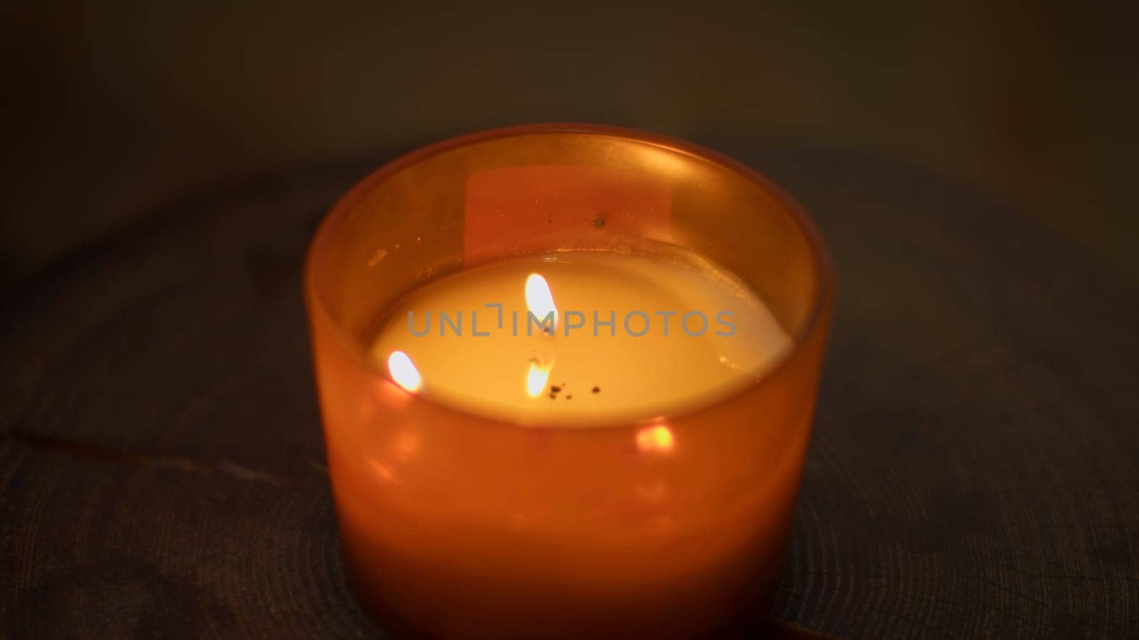 Close-up of flame of cozy candle. Media. Aromatic candle that creates cozy and spa atmosphere. Aroma candle with warm light and fragrance in spa.