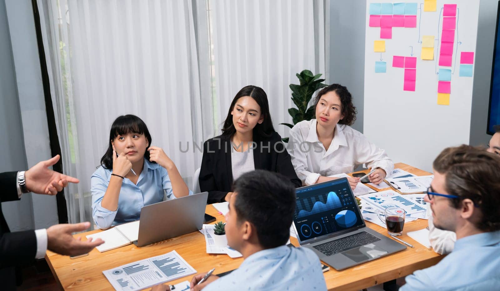 Diverse group of business analyst team analyzing financial data report paper on office table. Chart and graph dashboard by business intelligence analysis for strategic marketing planning Habiliment