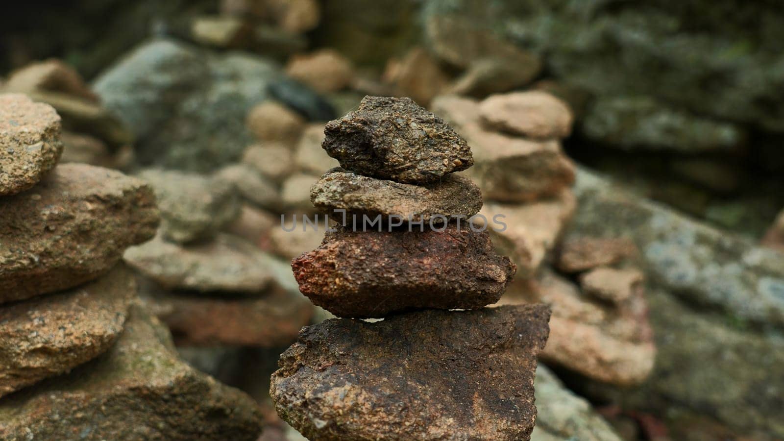 Close-up of stacked towers of stones. Clip. Mountain stones were stacked in turrets. Stacked turrets of rocks on background of rocks.