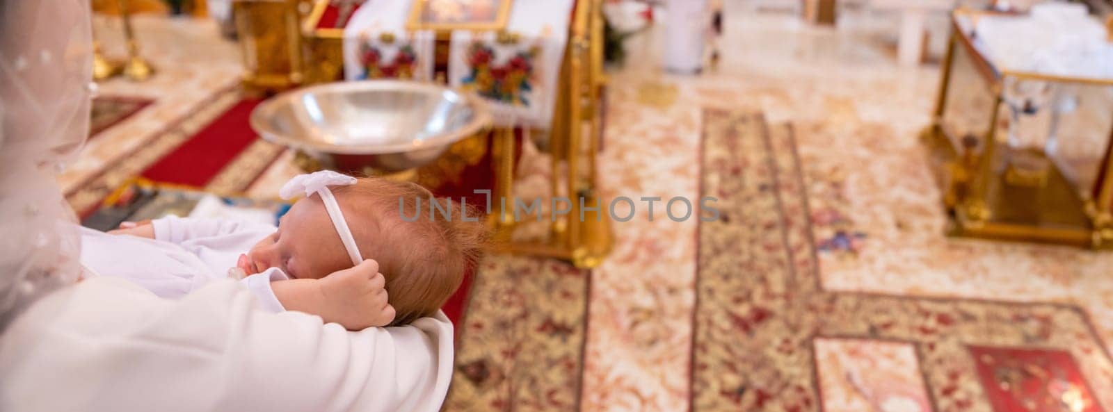 a woman holds a child in a church. baptism of a child. church