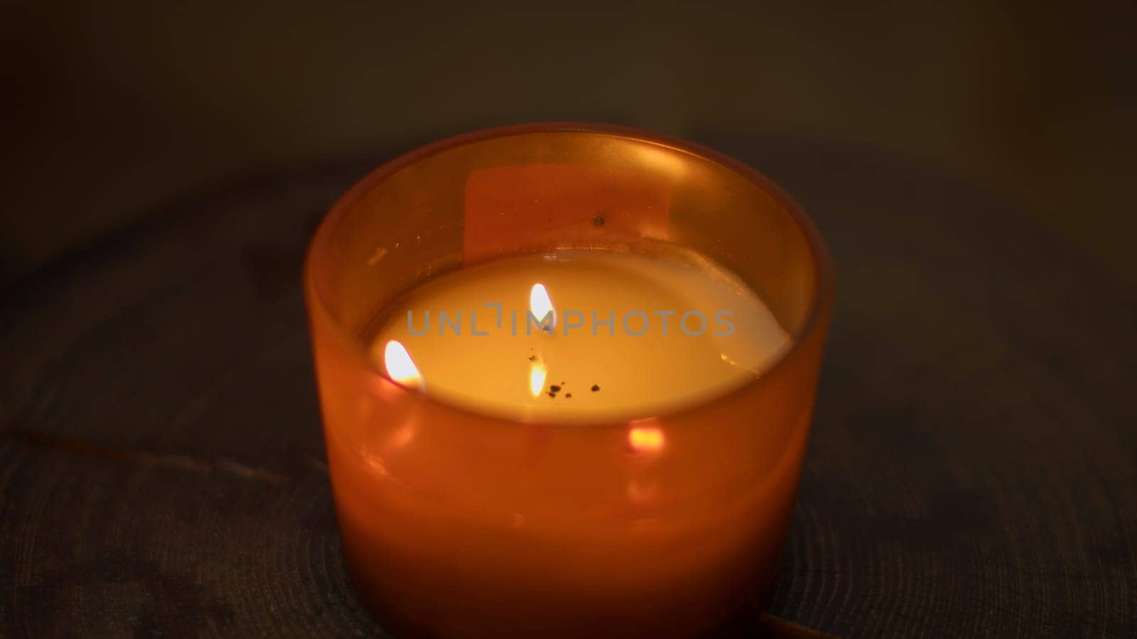 Close-up of flame of cozy candle. Media. Aromatic candle that creates cozy and spa atmosphere. Aroma candle with warm light and fragrance in spa by Mediawhalestock