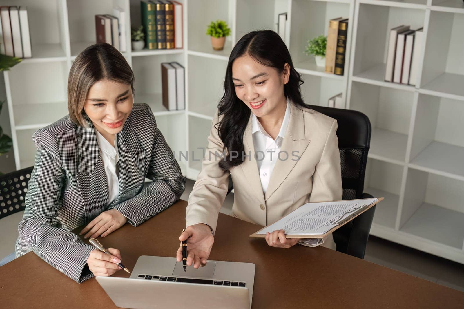 A young Asian lawyer and businesswoman discuss business law and financial contracts..