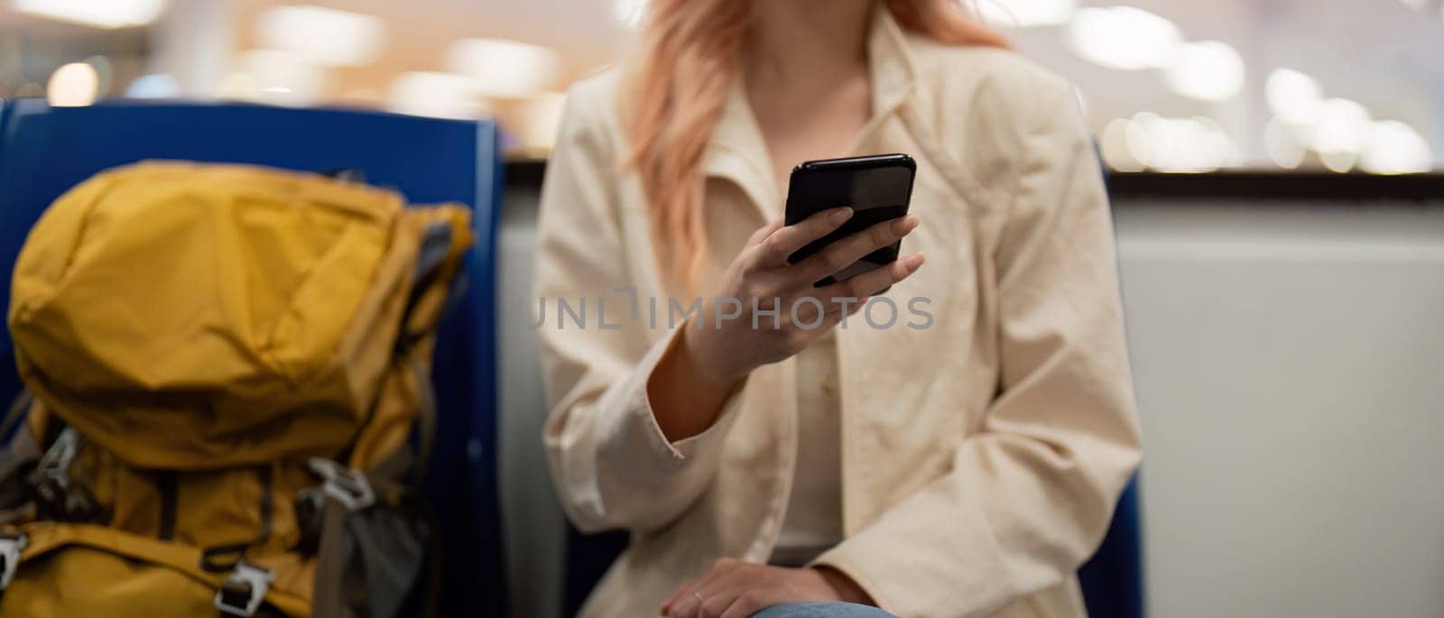 Tourist woman using mobile smartphone with suitcase traveling between waits for flight in Airport Terminal, flight check in, Tourist journey trip concept.