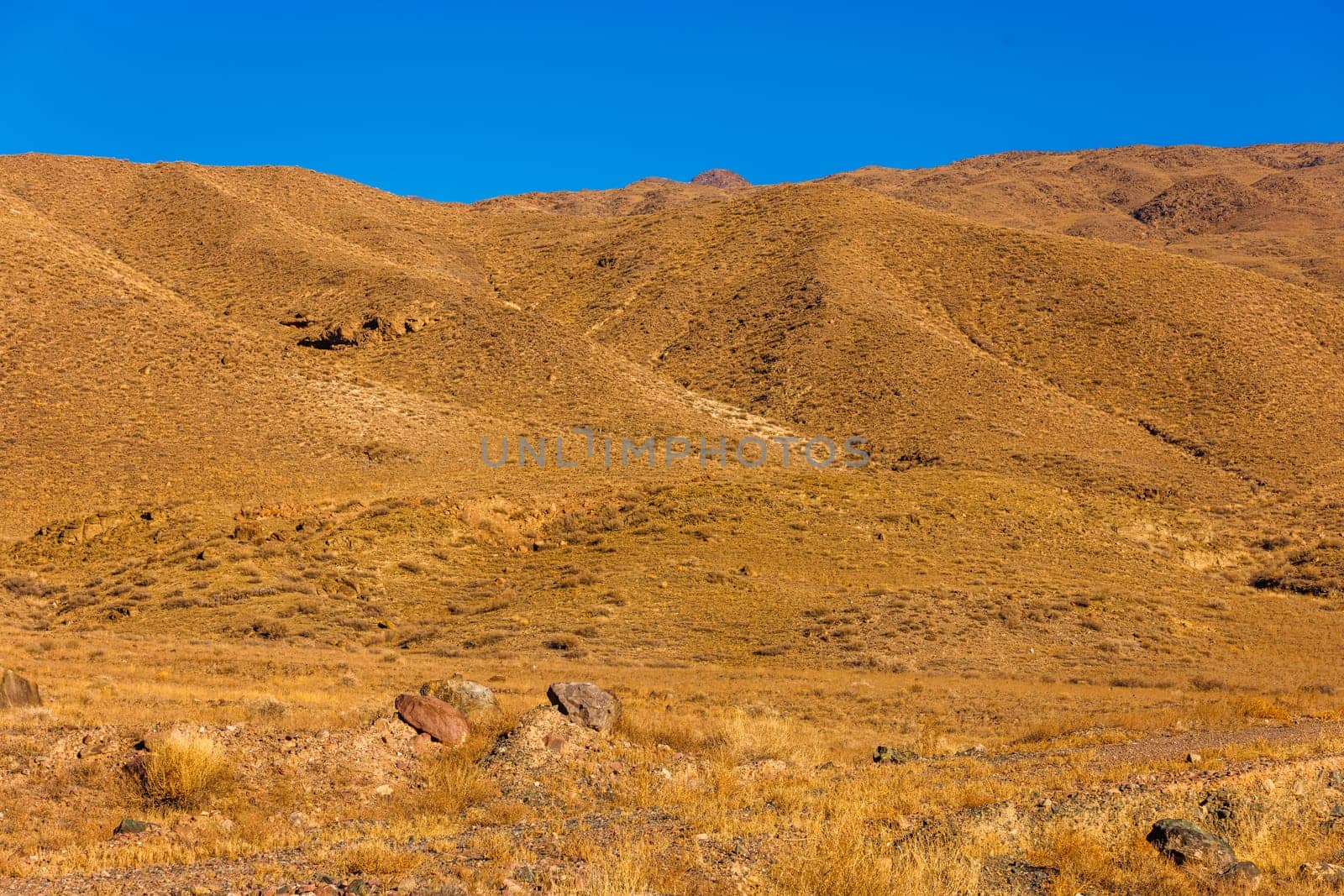 a mountain range with a blue sky in the background by z1b