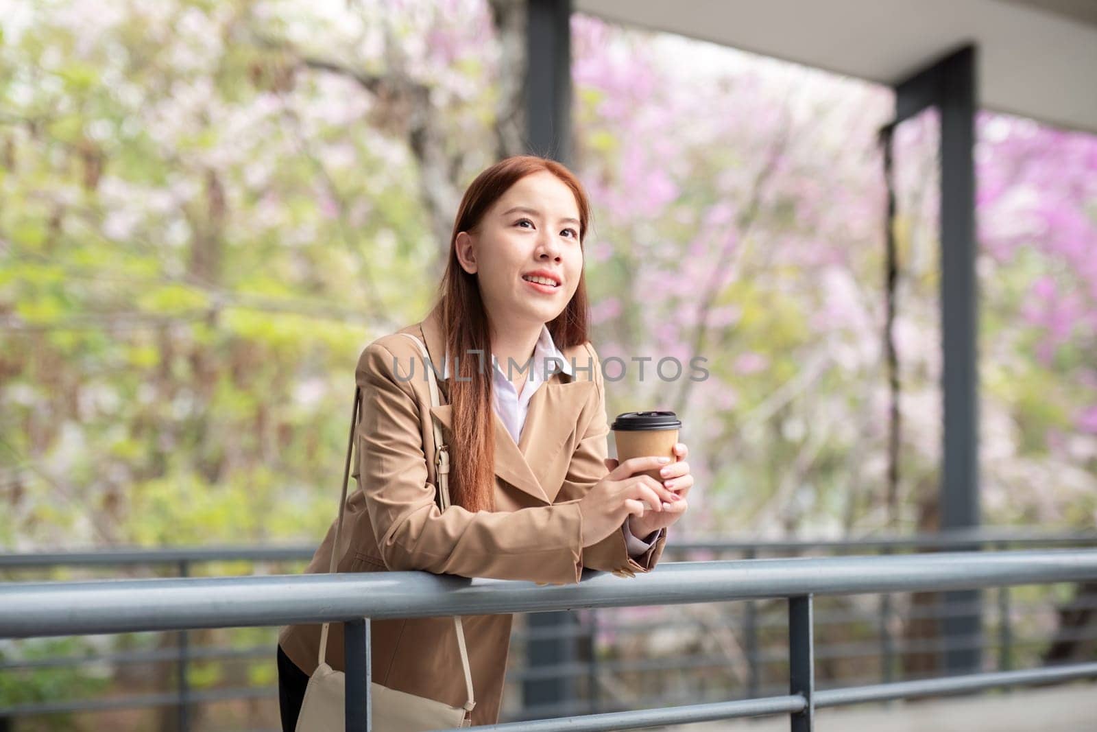 Beautiful successful business woman in walking on the street in business town with coffee. Preparation for the working day.