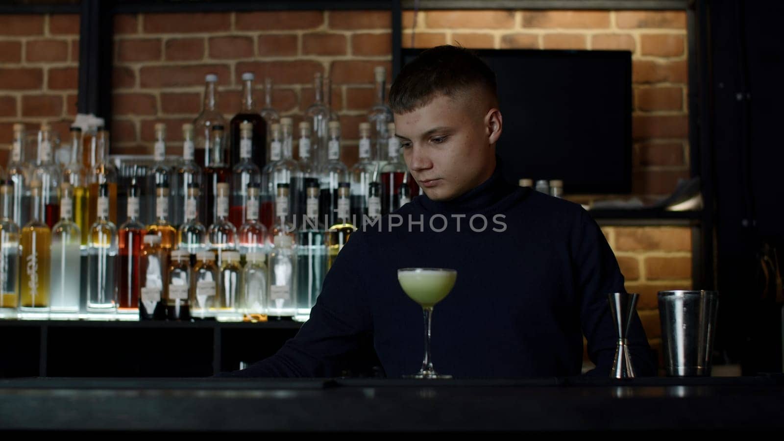 Handsome barman preparing cocktail drinks. Media. Concept of night life at bar, club, restaurant. by Mediawhalestock