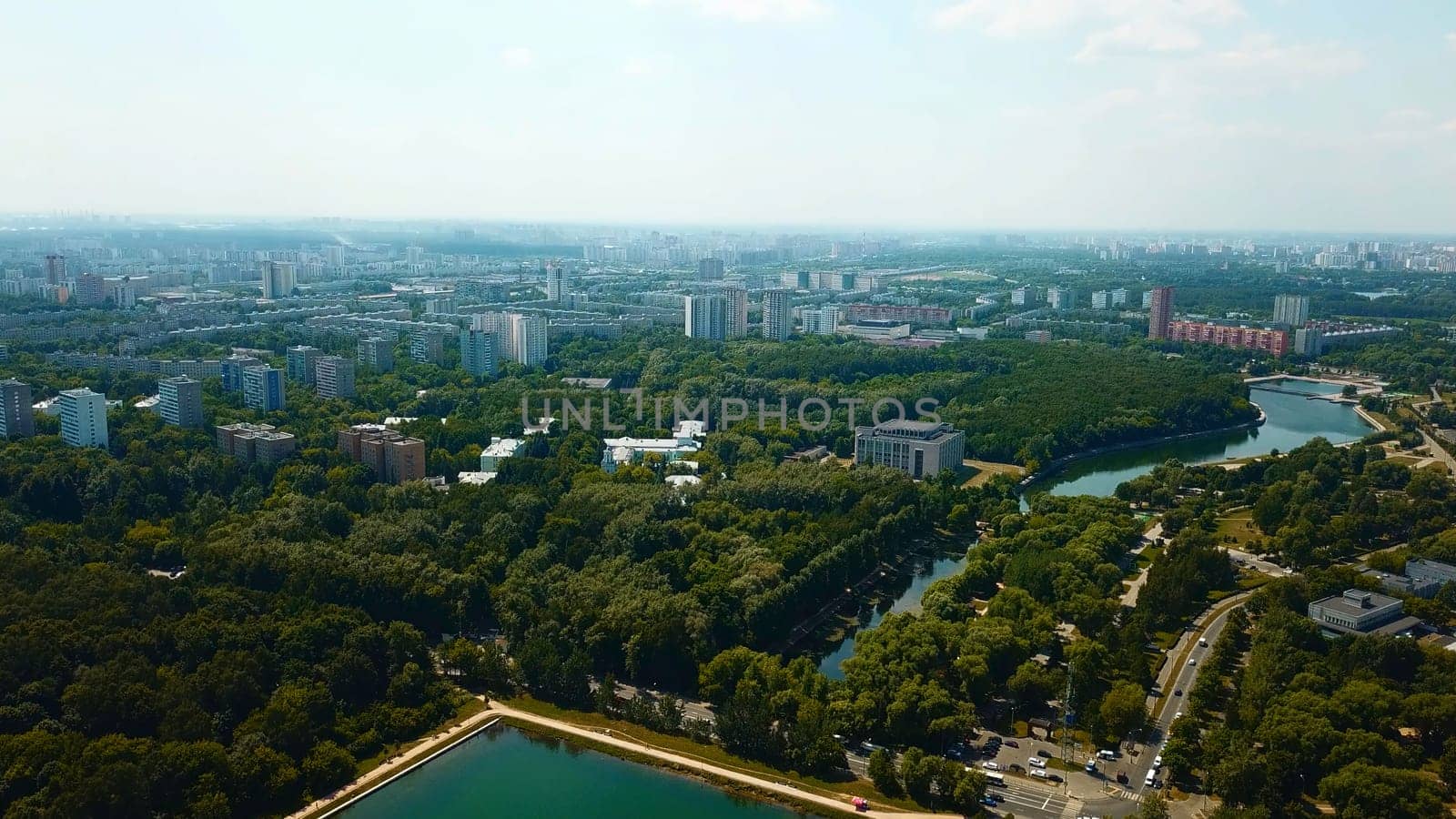 Top view of city with dam and river on sunny summer day. Creative. Beautiful green city with dam and canal on summer day. Skyline of modern city with green parks and clear canal by Mediawhalestock