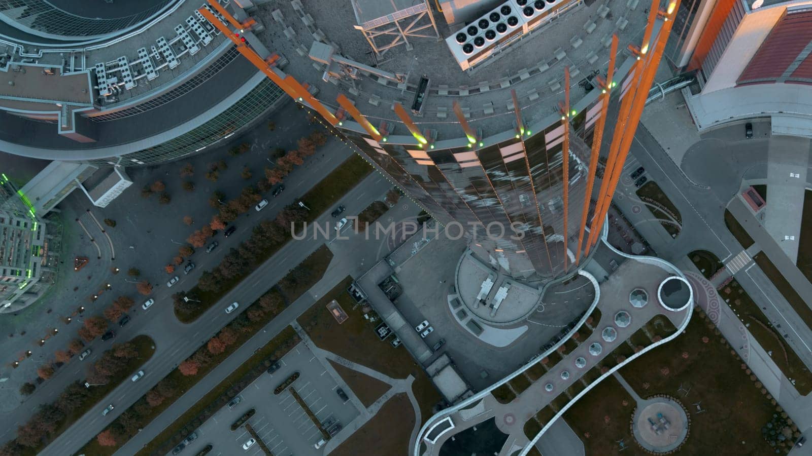Top view of colorful glowing high-rise on summer day. Stock footage. Beautiful facade of luminous high-rise in modern city. Modern architecture of high-rise buildings with luminous facade by Mediawhalestock