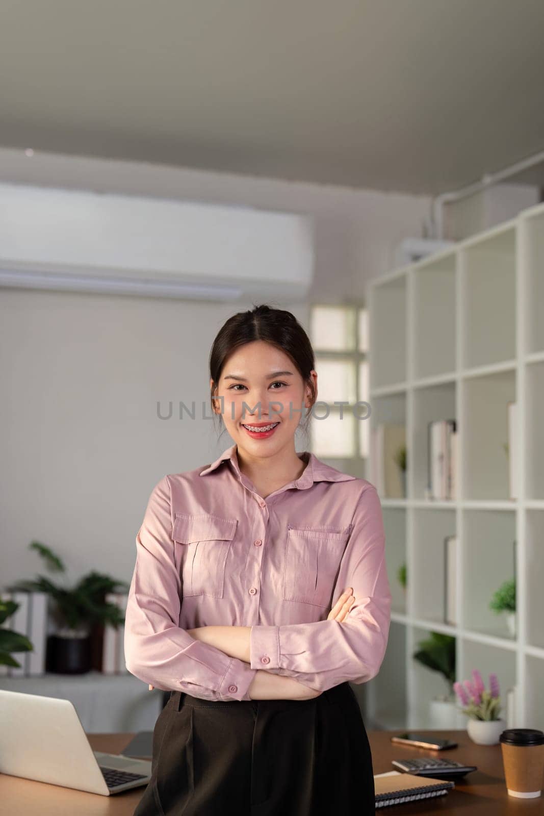 Young smiling successful employee business woman work stand at workplace desk at home office . Achievement career concept by nateemee