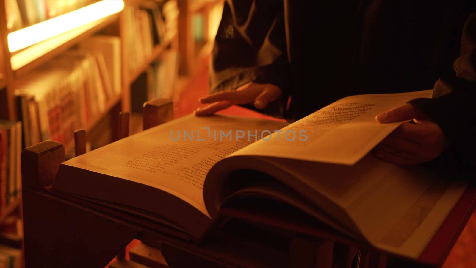 Man reading large mysterious book. Stock footage. Close-up of mysterious man reading ancient forbidden book in library. Secret society with books in night library by Mediawhalestock
