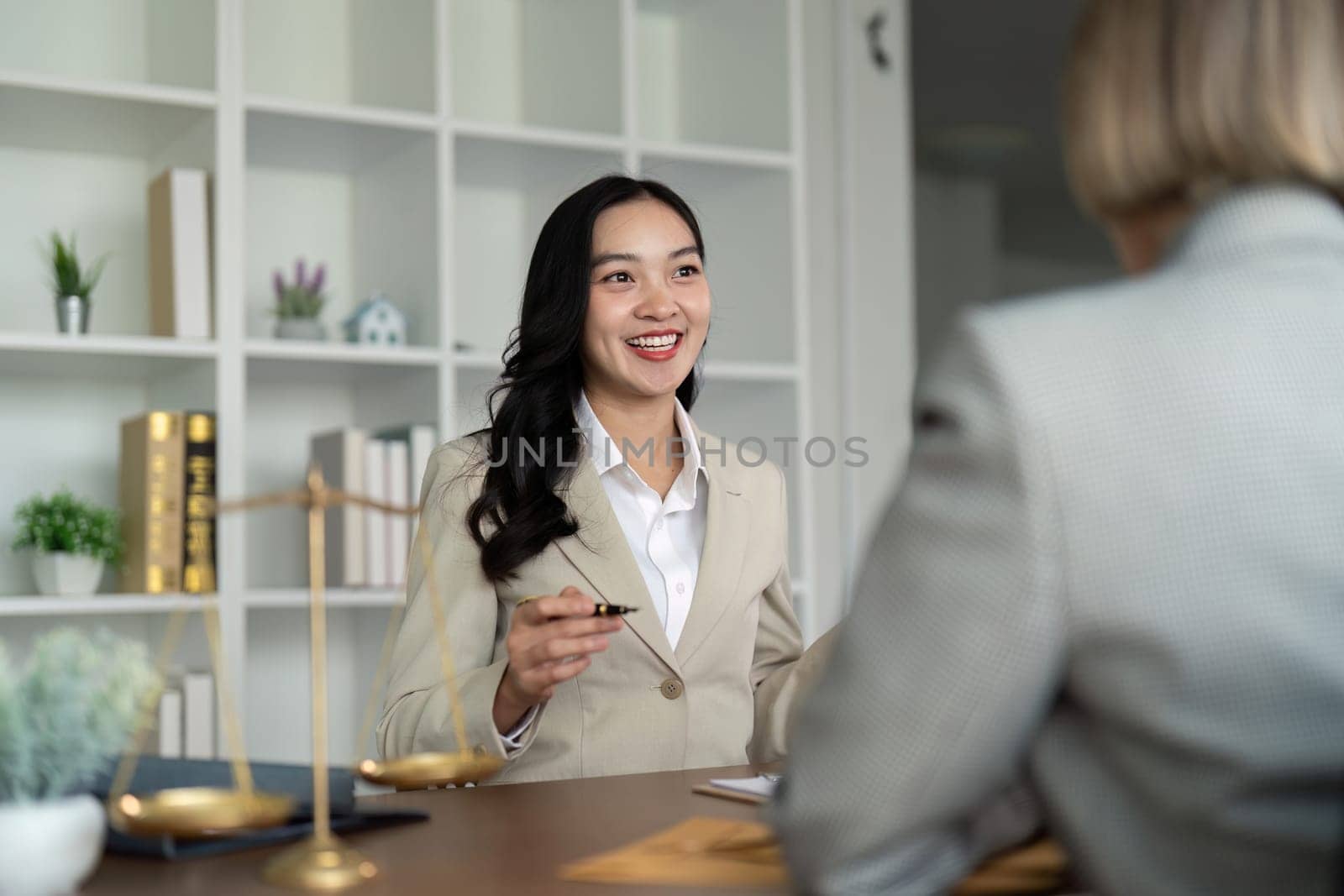 Lawyers woman and businesswoman discussing contract papers sitting at the table. Concepts of law, advice, legal service.