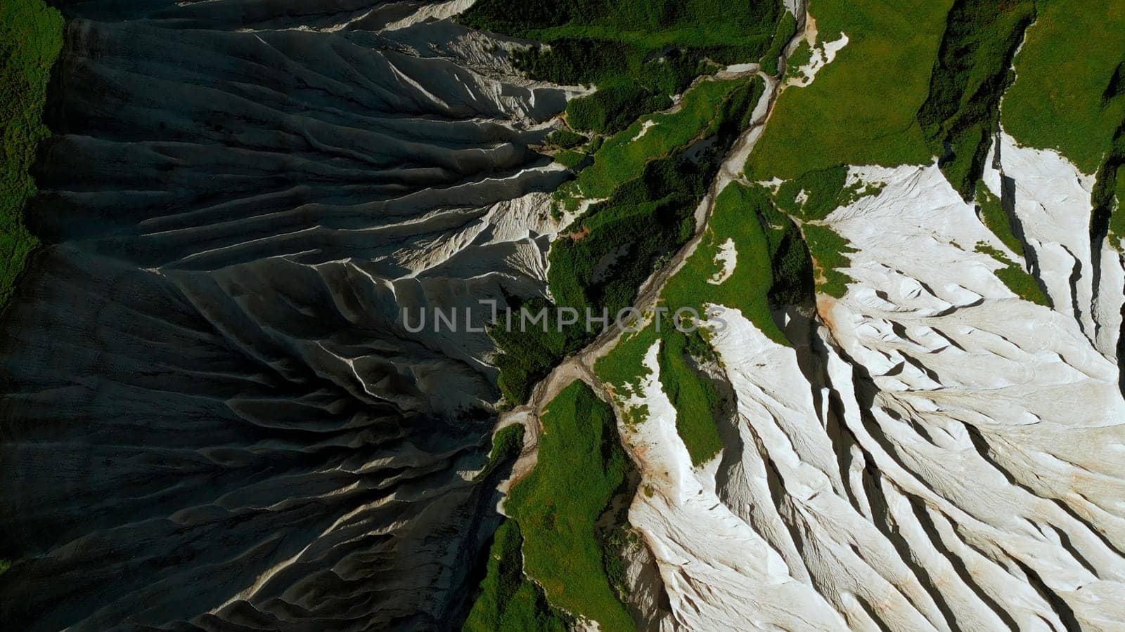 Top view of picturesque mountain peak. Clip. Frozen stone formations and green grass